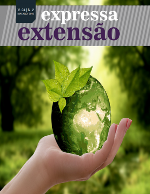 Capa da Revista Expressa Extensão, mostra uma mão segurando uma semente, que, em seu interior, mostra o mapa mundi.